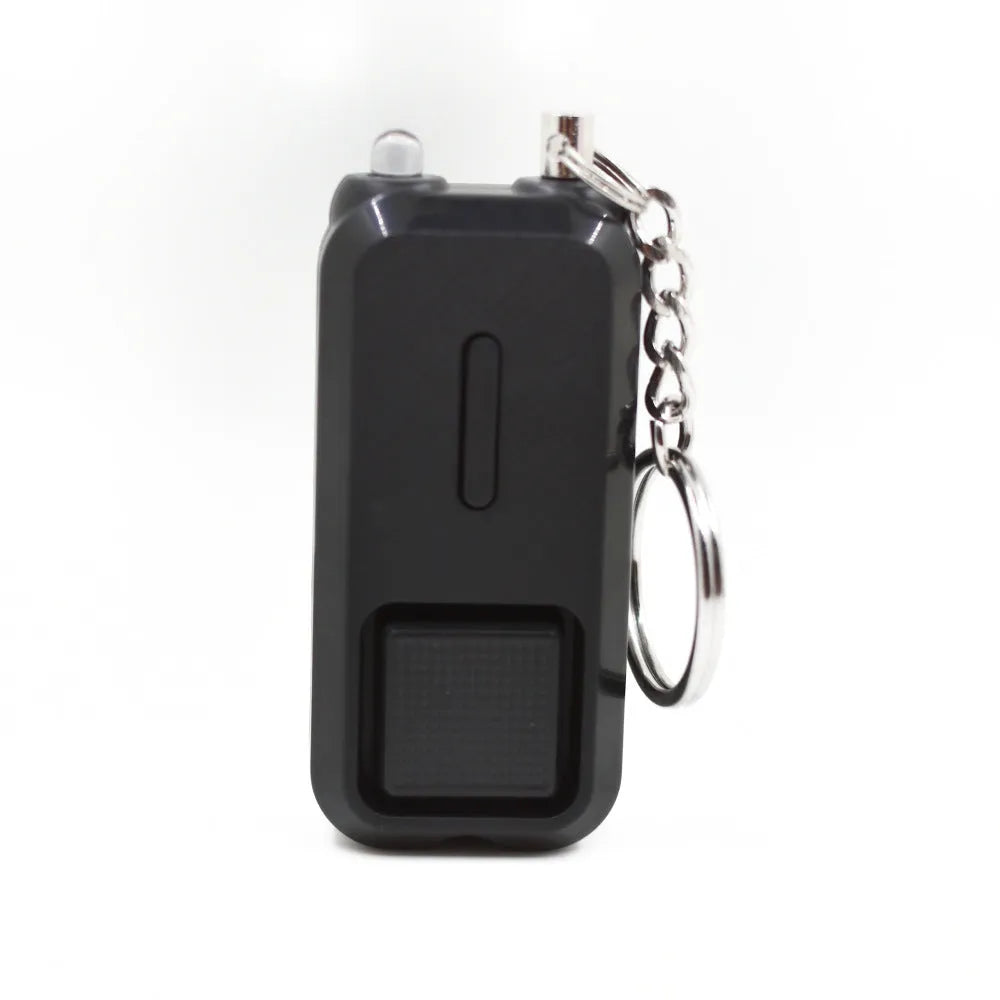 Small pink personal safety alarm on a keyring with a white box.