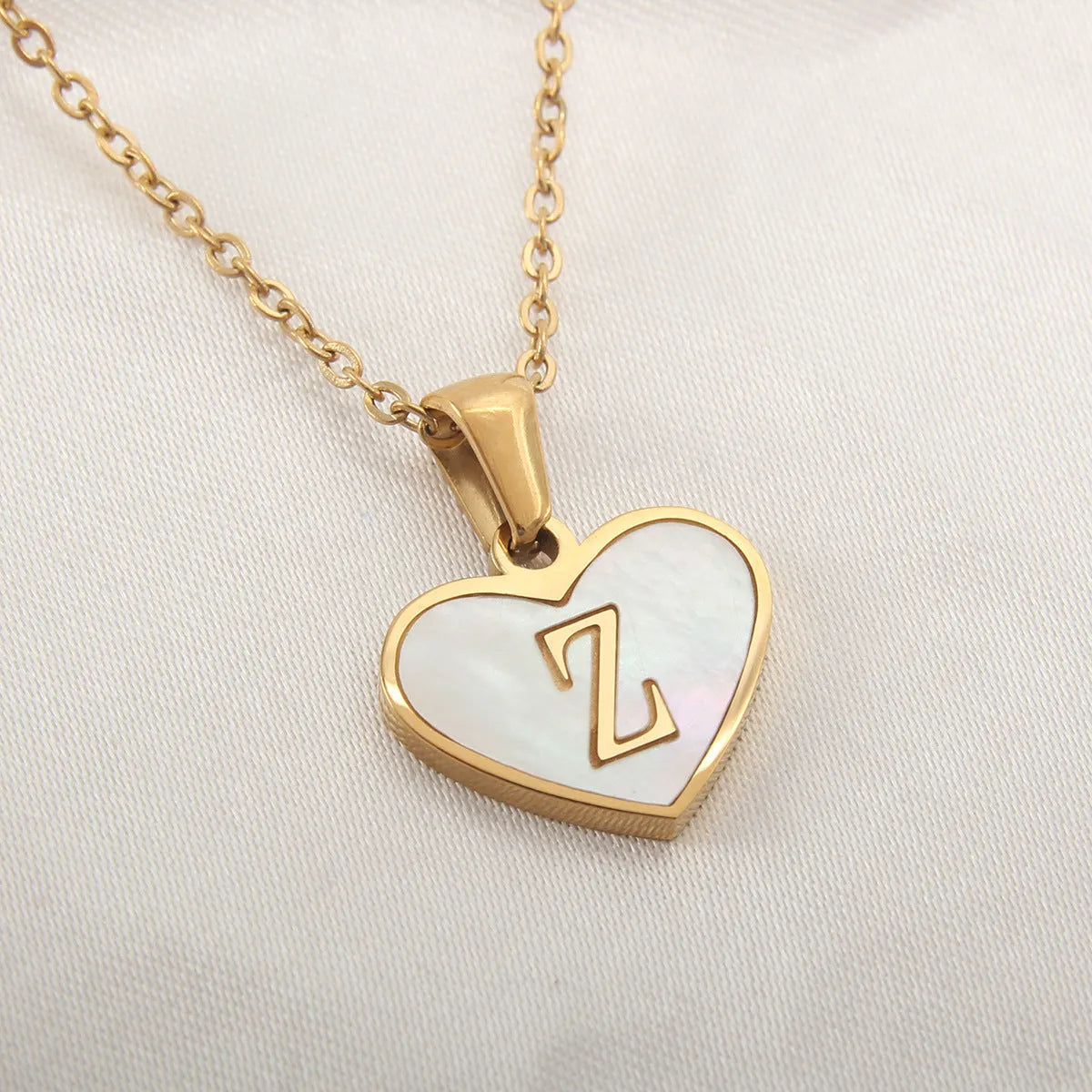 Gold plated initial necklace with white shell heart pendant and adjustable chain