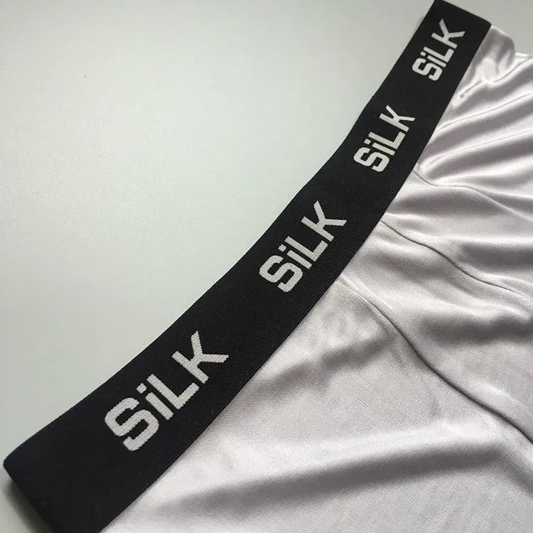 Men's loose fitting silk shorts in navy blue, shown on a mid-waist.