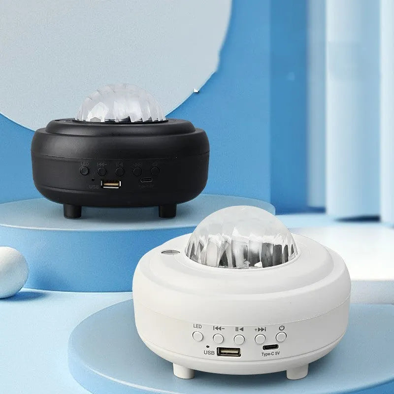 White Galaxy Star Projector night light with Bluetooth speaker on a table