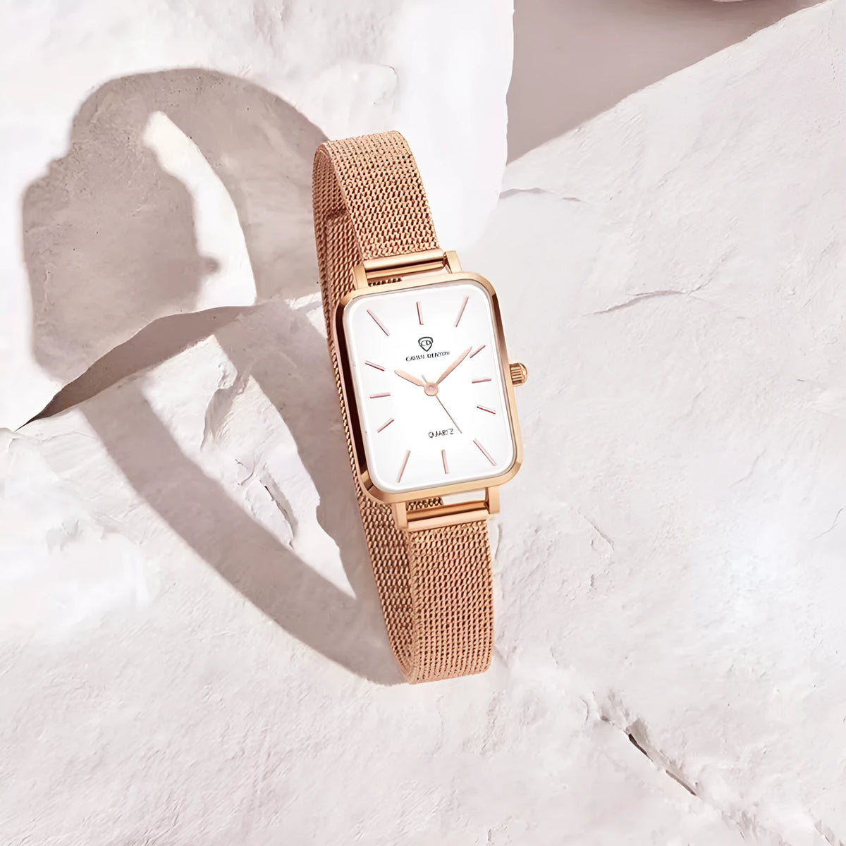 Rose gold women's waterproof quartz watch with woven steel strap on wrist.
