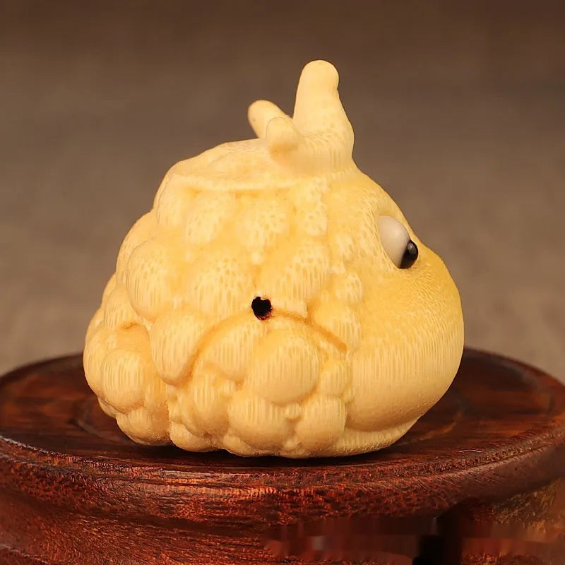 Solid bamboo carving of a cute style Crown Princess Toad ornament on display