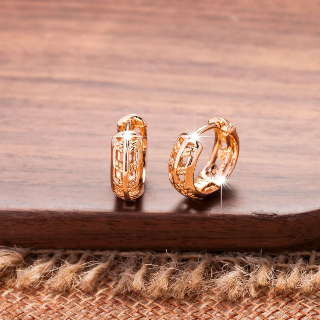 Rose gold copper earrings with hollowed-out heart and leaf designs on white background