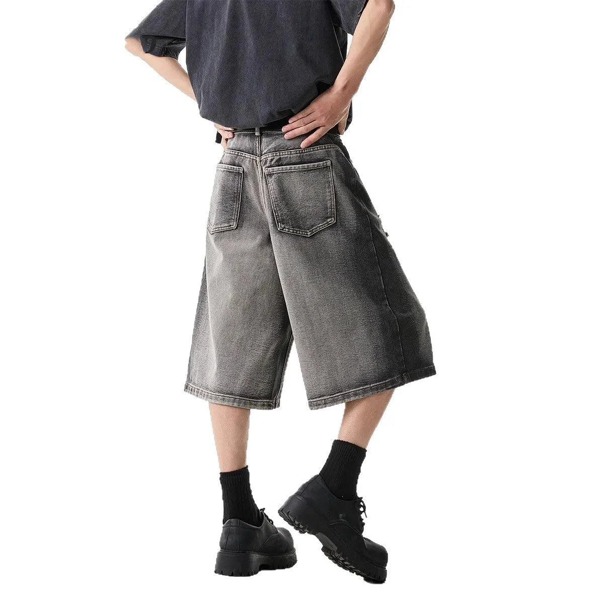 Grey women's denim shorts with a water washed finish, distressed holes, and a loose cropped fit.