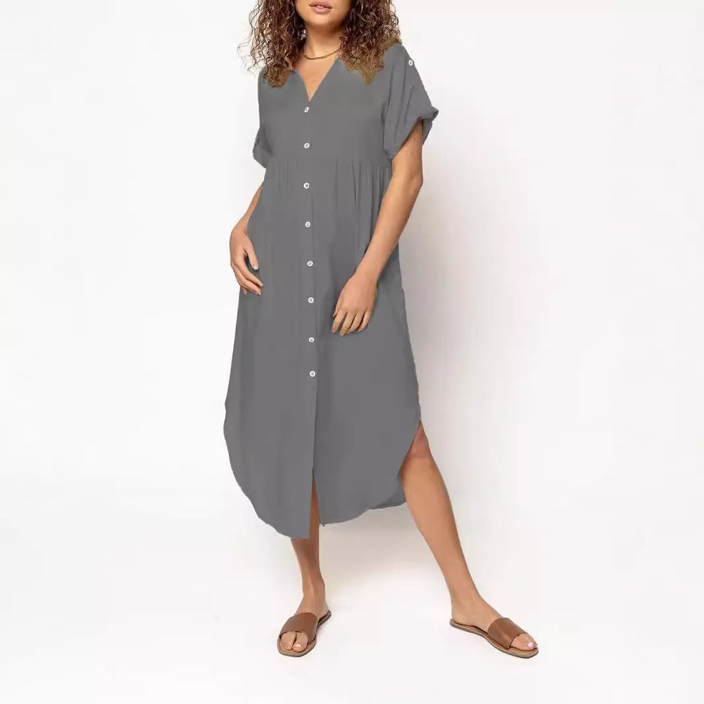 A woman wearing a loose-fitting, mid-length apricot-coloured casual dress with a button-down front.