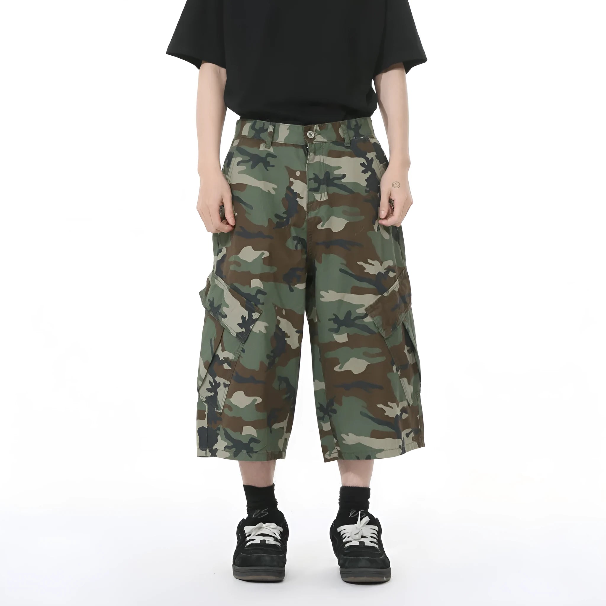 Men's loose-fit camouflage cotton trousers with wide legs, cropped hem, side stitching, and large front pockets.