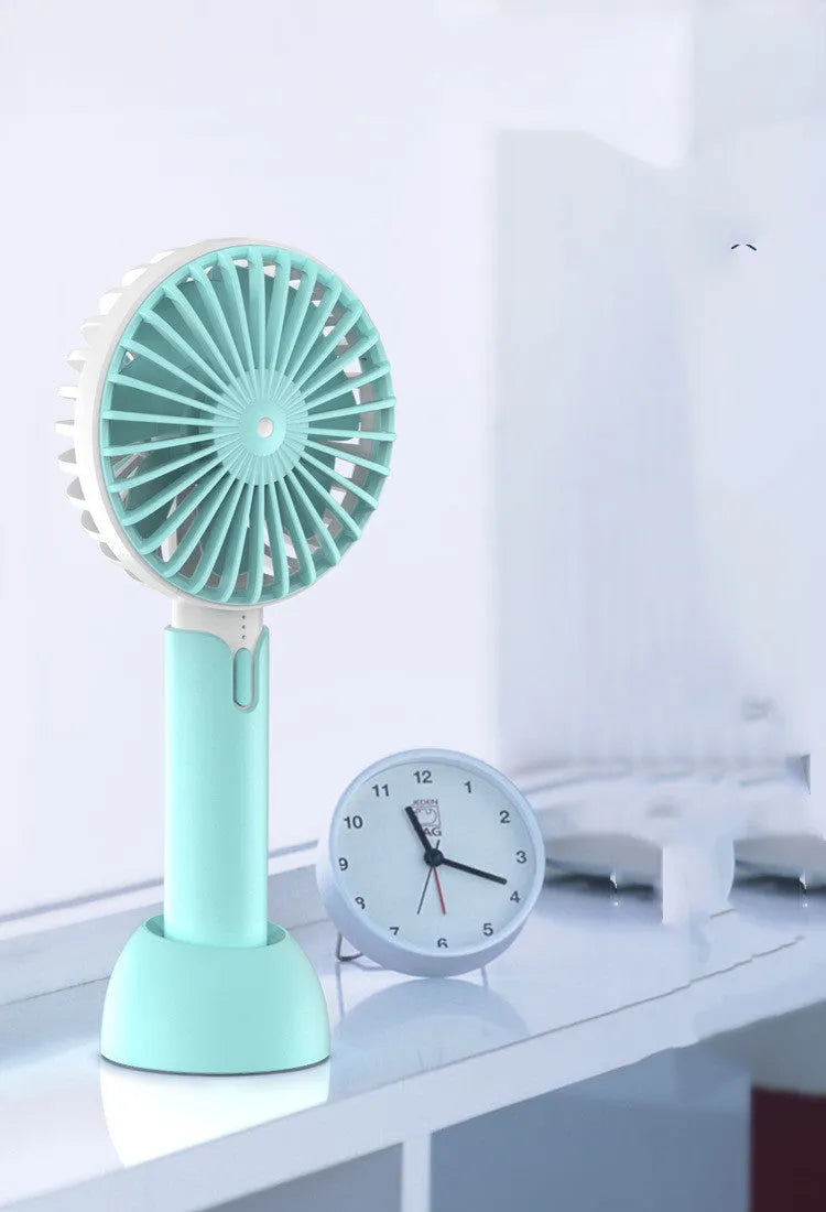 Blue handheld mini USB electric desk fan with oscillating head on a desktop