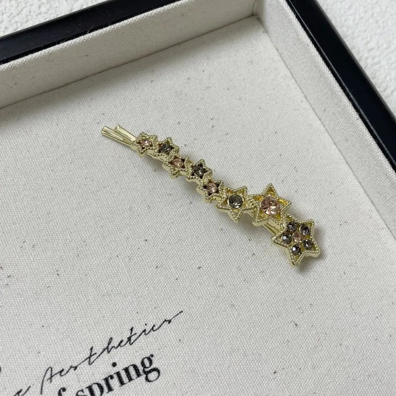 Gold electroplated rhinestone barrette with star design and side clip for bangs