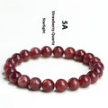 Natural cherry red strawberry quartz bracelet with polished geometric beads on a white background.