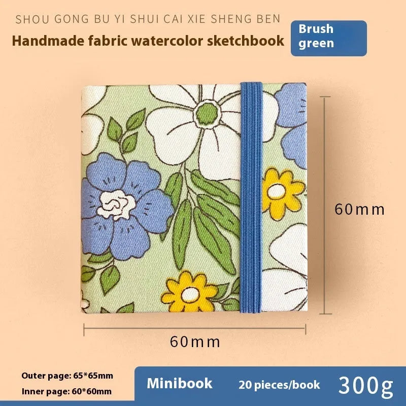 Feiluniao fabric watercolour sketchbook open showing a detailed hand-painted design on paper.