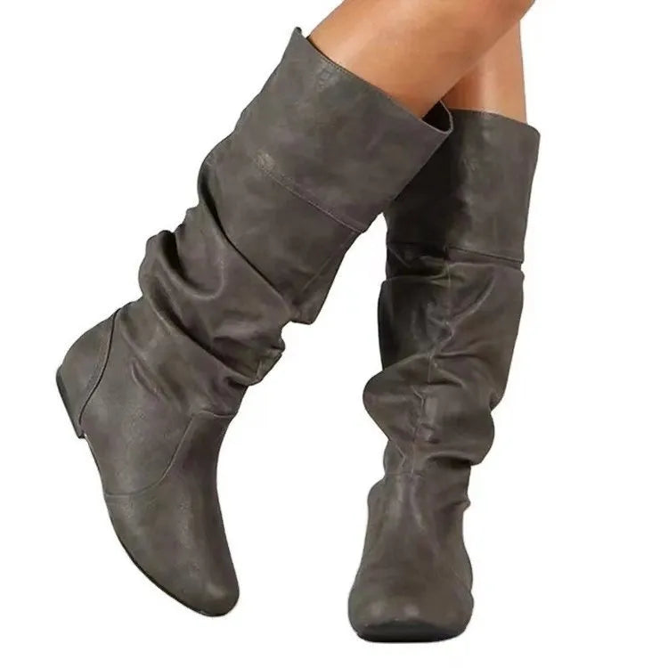 Women's black flat slip-on ankle boots with round toe and high shaft on a neutral background