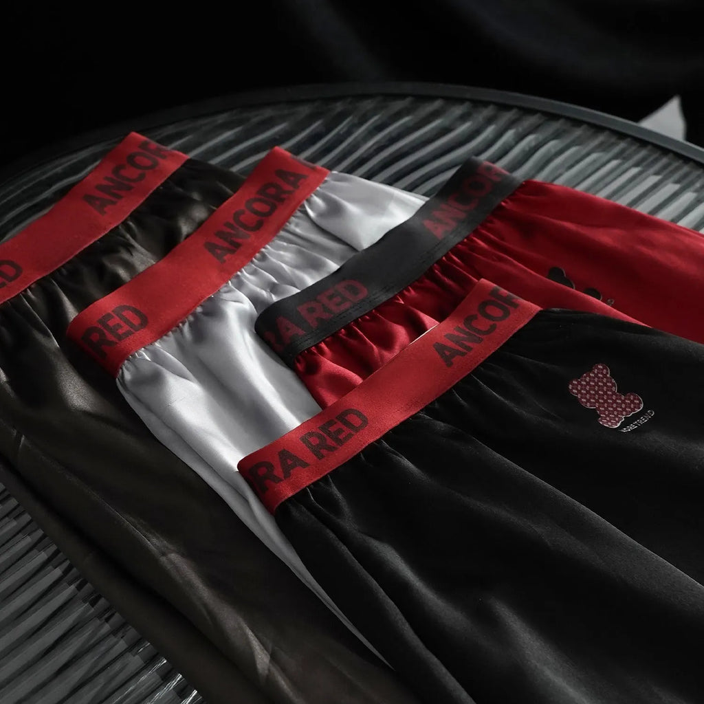 Men's solid colour polyester boxer briefs in black, shown laid flat to display the mid waist design.