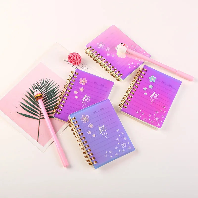Four A7 spiral-bound pocket notebooks showing different PP cover designs: Constellation, Sakura, Universe, and Ocean.
