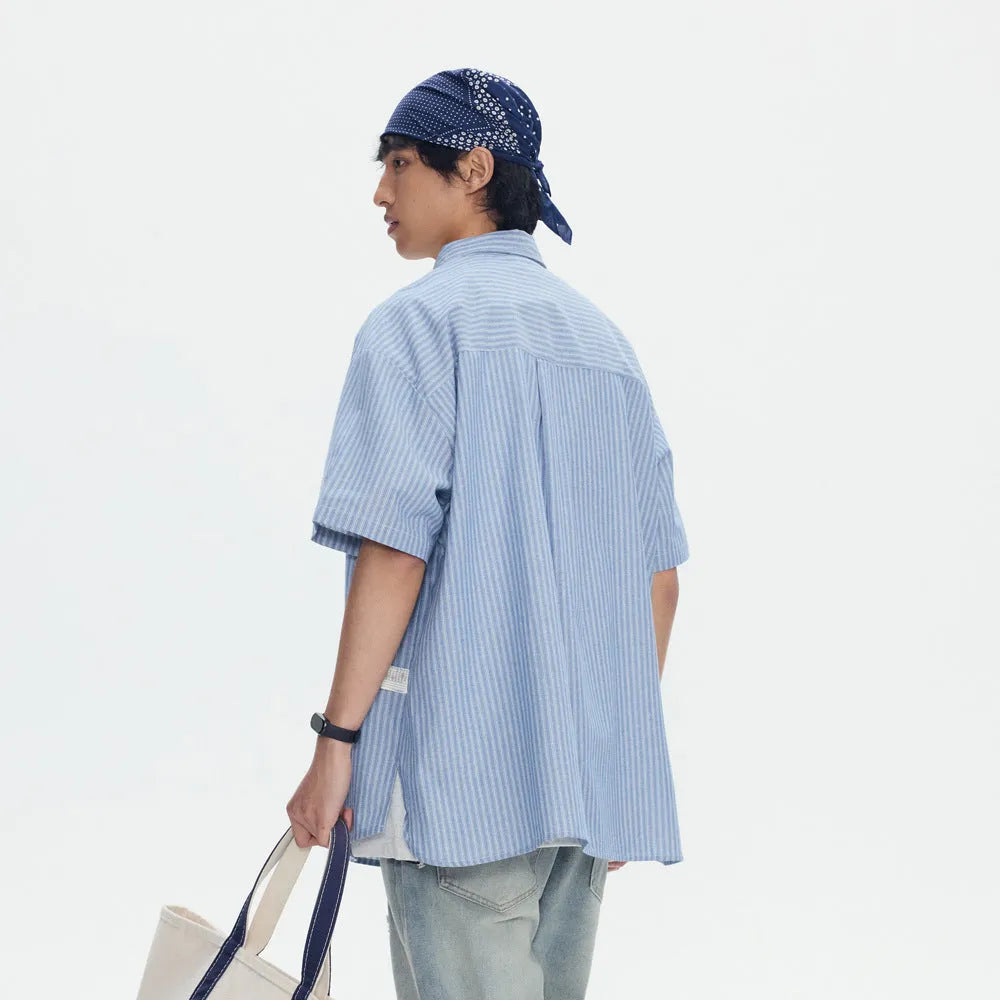 Blue and white striped loose-fitting short-sleeved shirt on a hanger