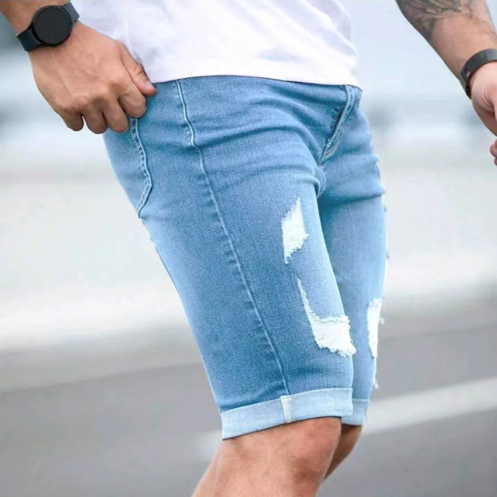 Sky blue distressed denim shorts with multi-hole design and low waist straight leg cut