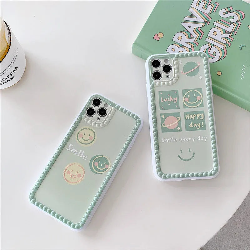 Green TPU iPhone case with a smiley face and polka dot geometric design on a table.