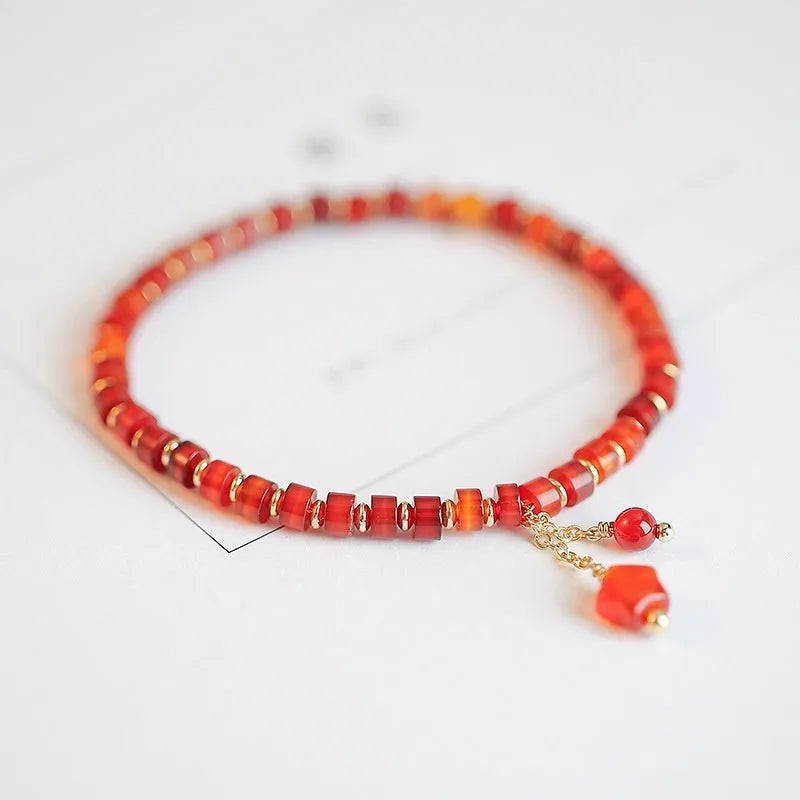 Hand-woven red agate bracelet with diamond-shaped beads and ethnic woven patterns