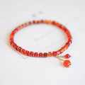 Hand-woven red agate bracelet with diamond-shaped beads and ethnic woven patterns