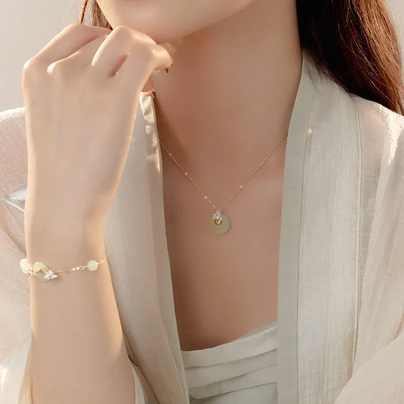 Silver orchid pendant necklace with geometric details and a safety buckle on an O-ring chain.