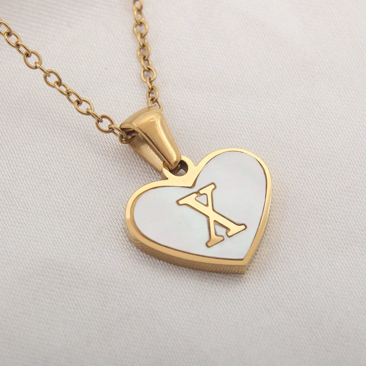 Gold plated initial necklace with white shell heart pendant and adjustable chain