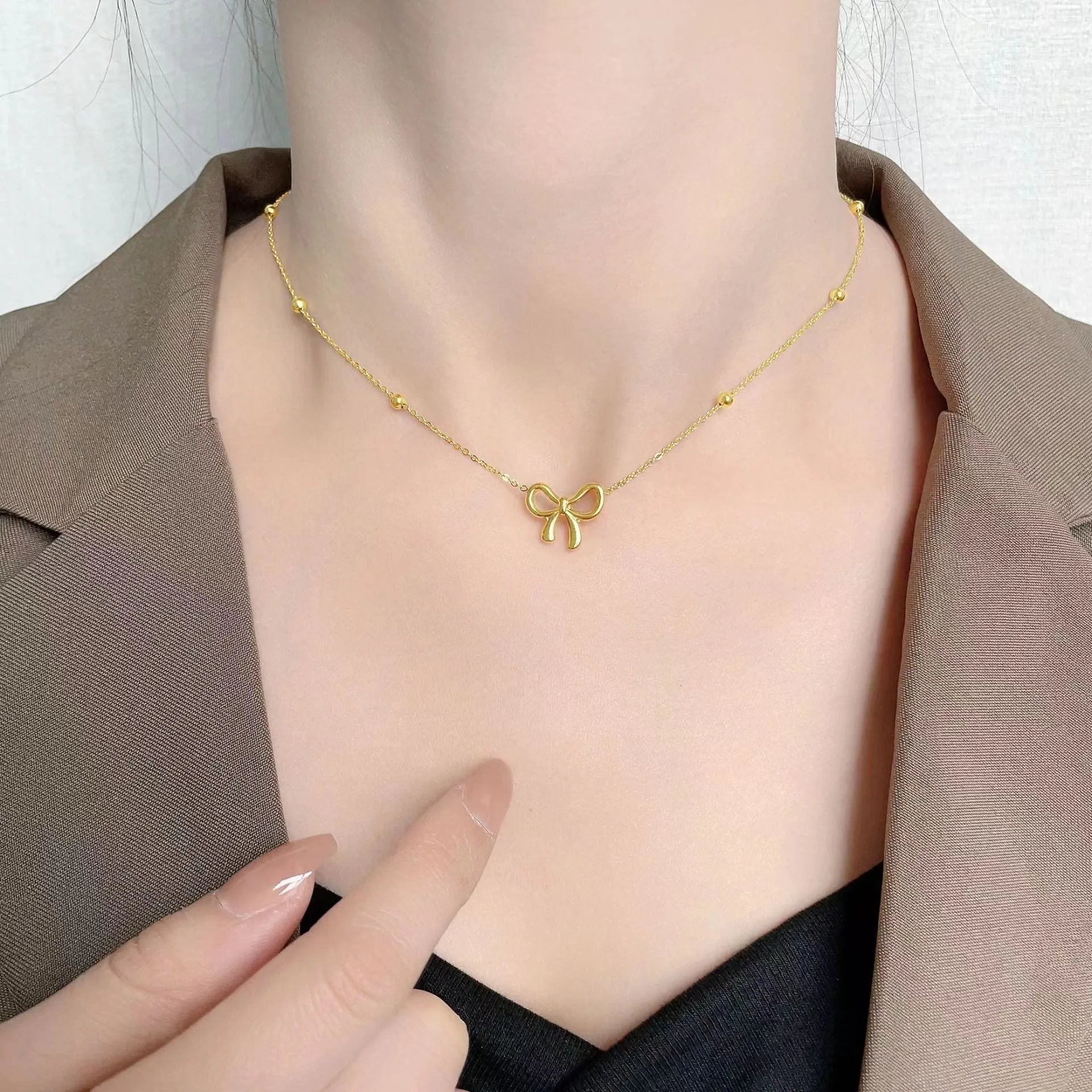 Gold-coloured women's bow necklace with cross chain design on adjustable 41-50cm perimeter