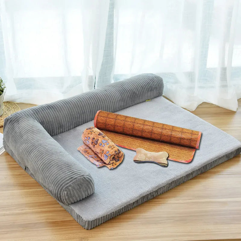 Corduroy pet sofa dog bed with bolster, shown in a grey colour on a wooden floor.