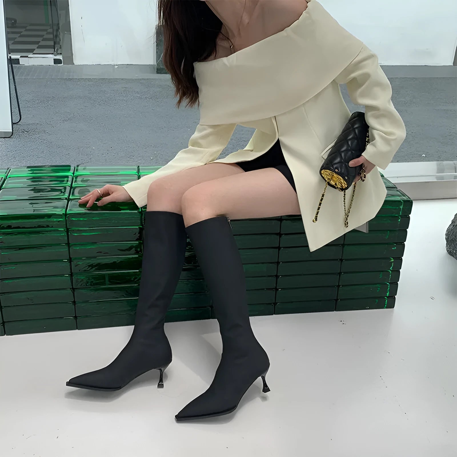 Black pointed toe women's boots with a back zipper and a stiletto heel.