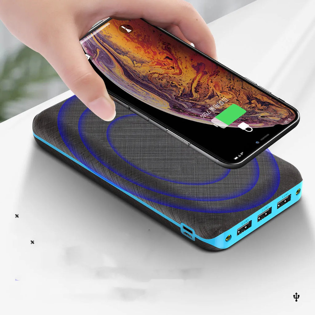 Black portable power bank with wireless Qi charging pad, three USB ports, and LED flashlight