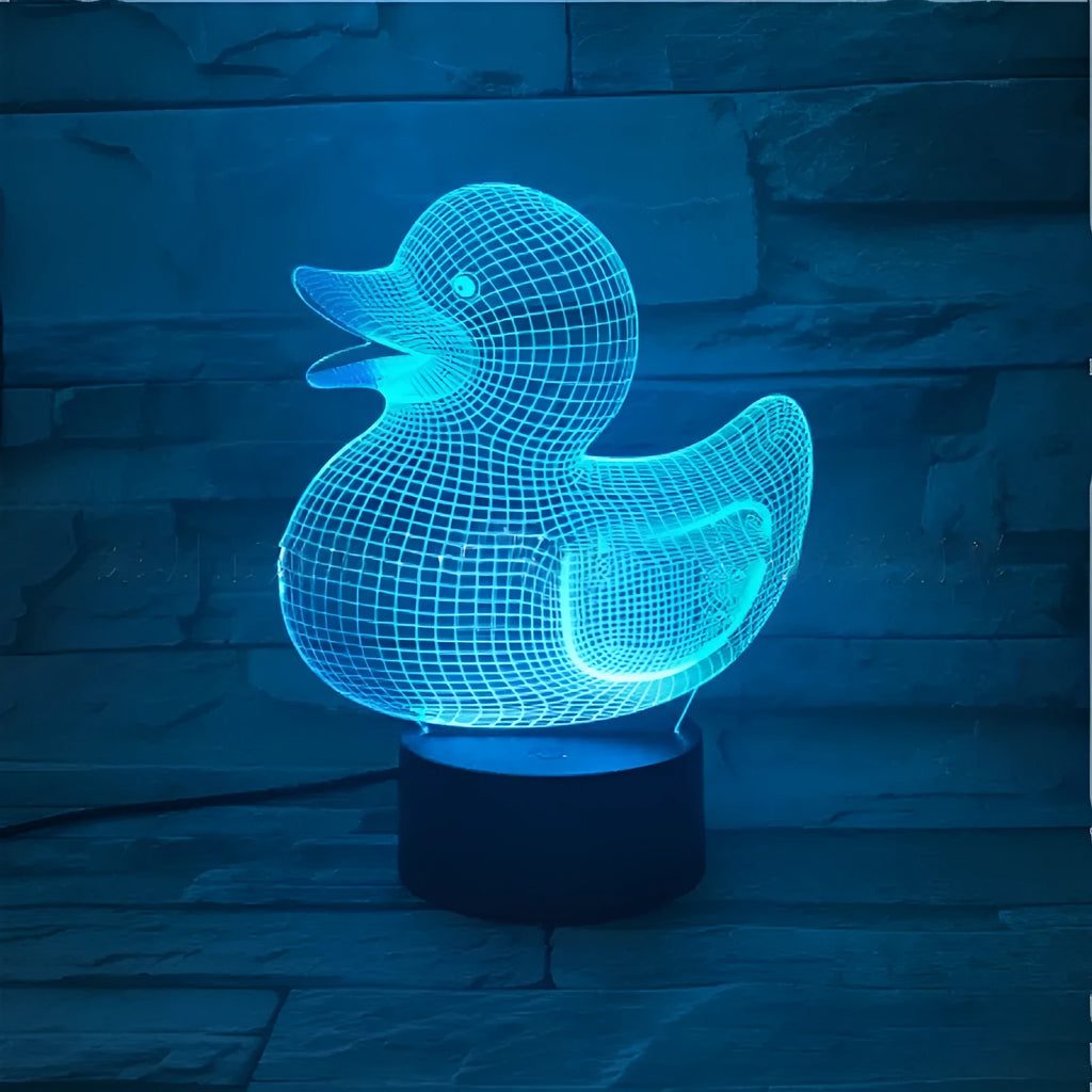 Little Yellow Duck 3D LED night light on a table showing its colourful illuminated display and remote control.