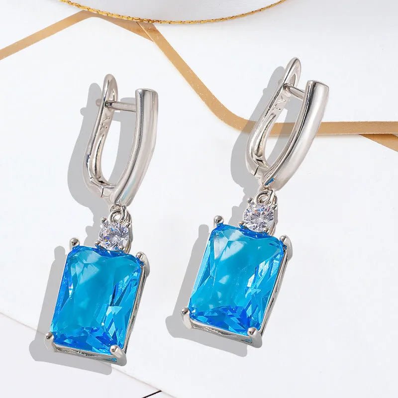 A pair of square, geometric earrings with a gold electroplated finish on a copper base.