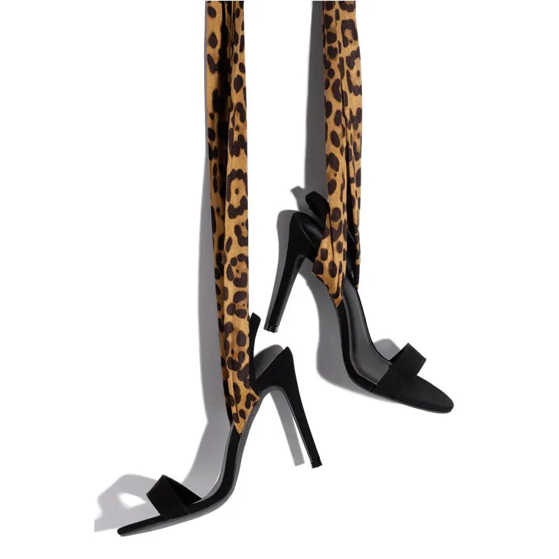 Light brown leopard print women's high-heel sandals with cross straps and a thin stiletto heel.