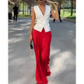Women's beige two-piece set with deep V-neck sleeveless top and high-waist wide-leg trousers.