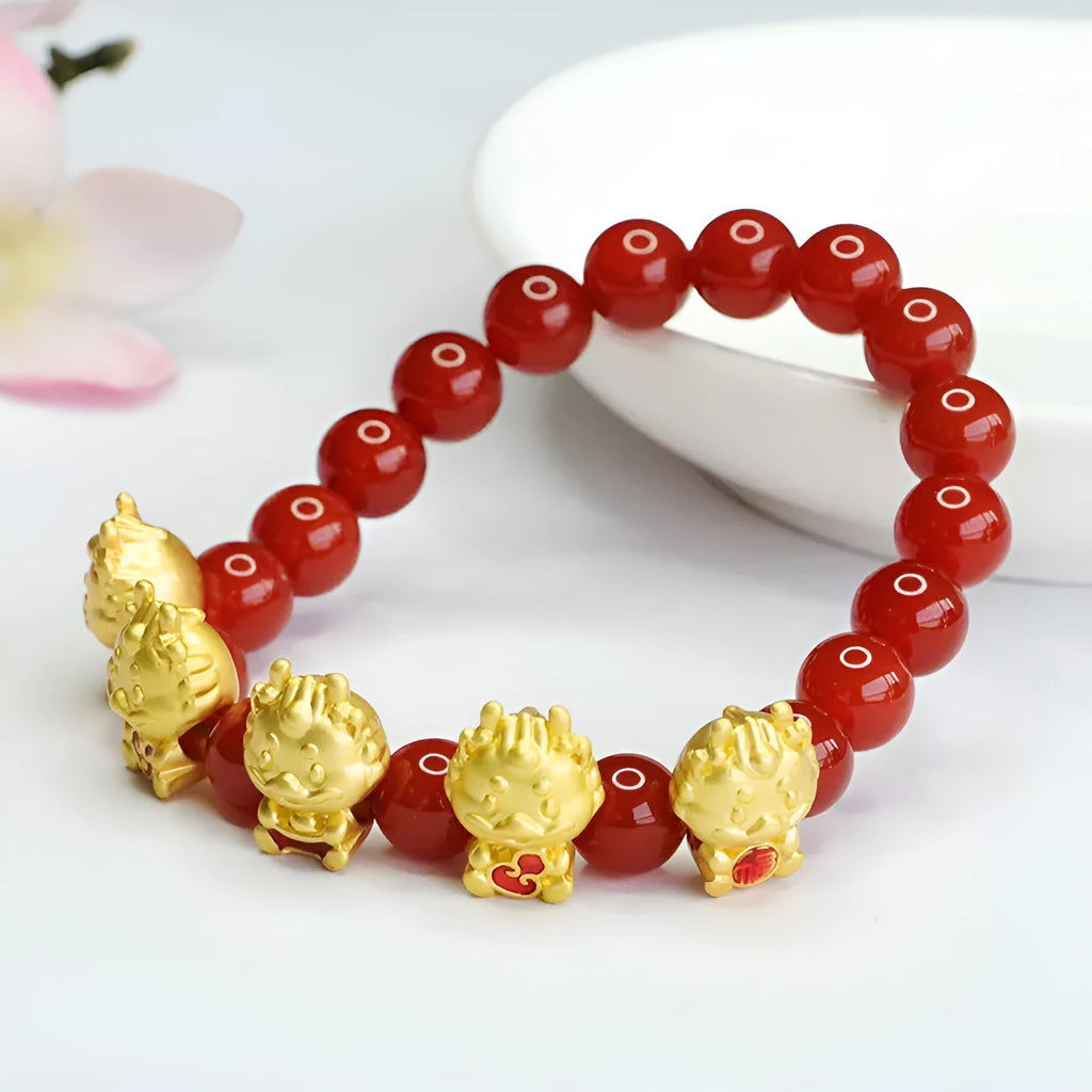 Natural red agate bead bracelet with a detailed five blessings dragon charm on a white background.