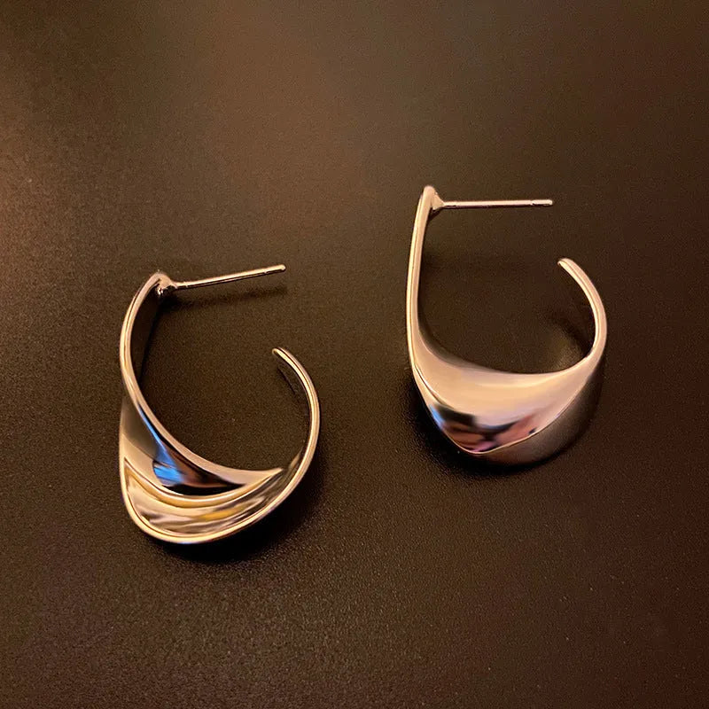 Geometric twisted metal earrings with round elements in gold or silver electroplated finish