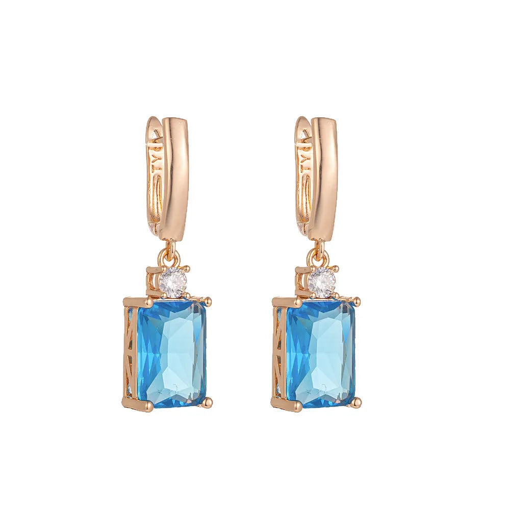 A pair of square, geometric earrings with a gold electroplated finish on a copper base.