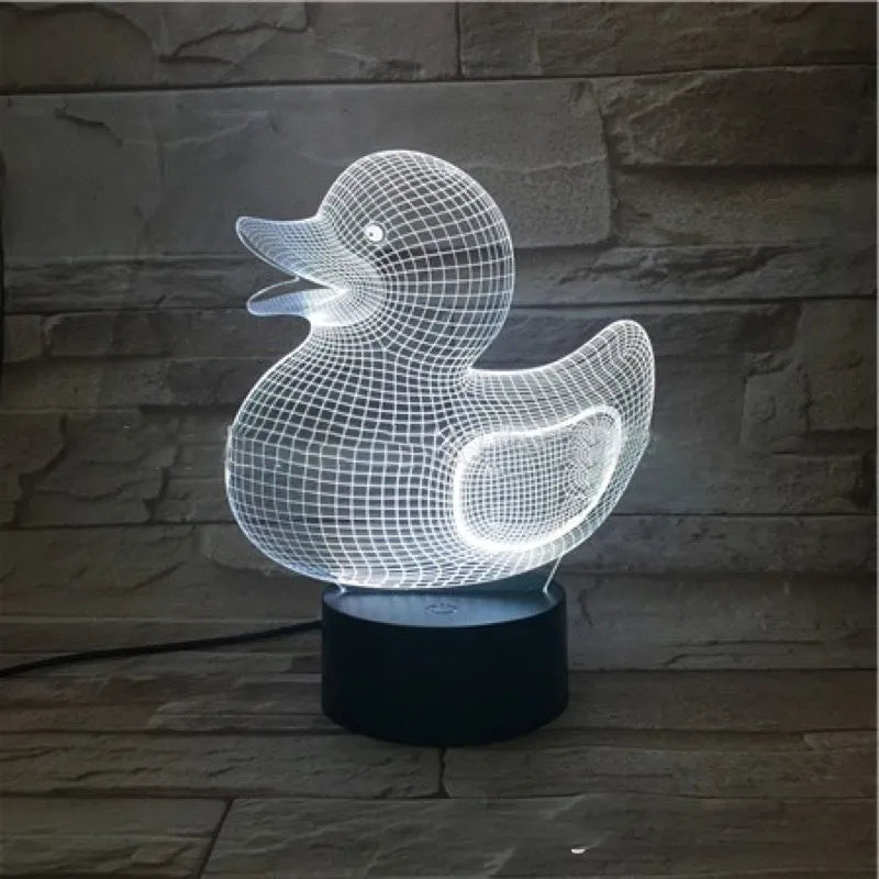 Little Yellow Duck 3D LED night light on a table showing its colourful illuminated display and remote control.