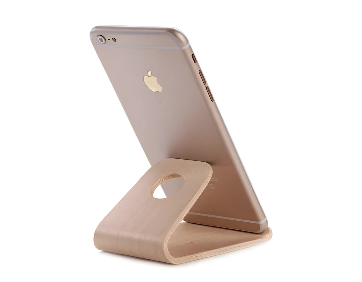 Minimalist wooden phone stand for Apple iPhone in walnut finish on a desk.