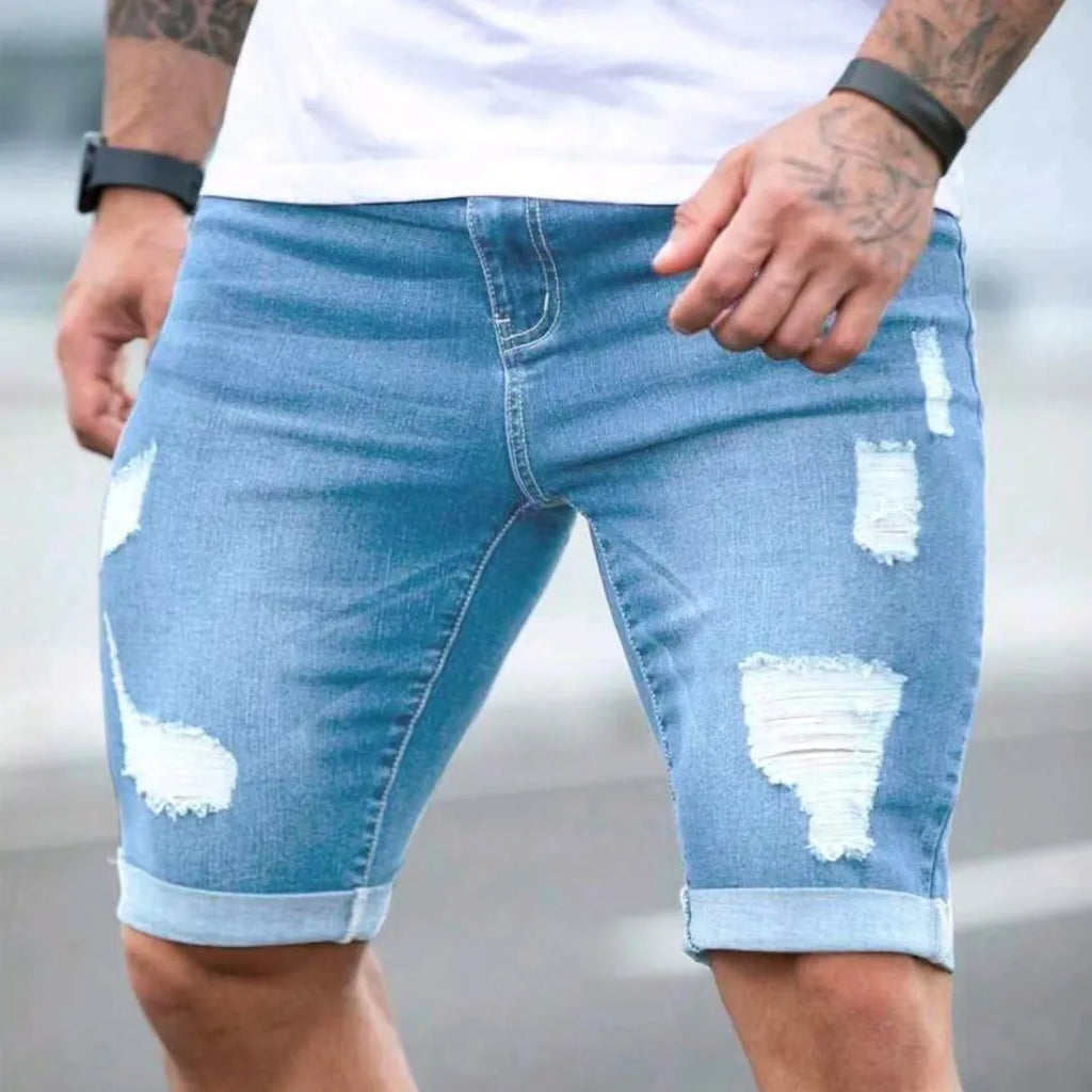 Sky blue distressed denim shorts with multi-hole design and low waist straight leg cut