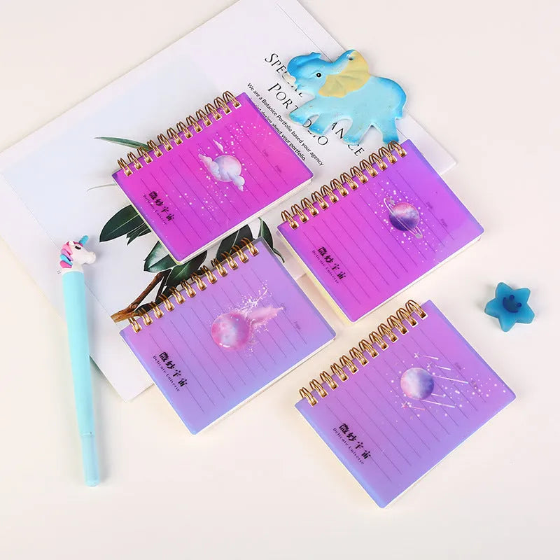 Four A7 spiral-bound pocket notebooks showing different PP cover designs: Constellation, Sakura, Universe, and Ocean.