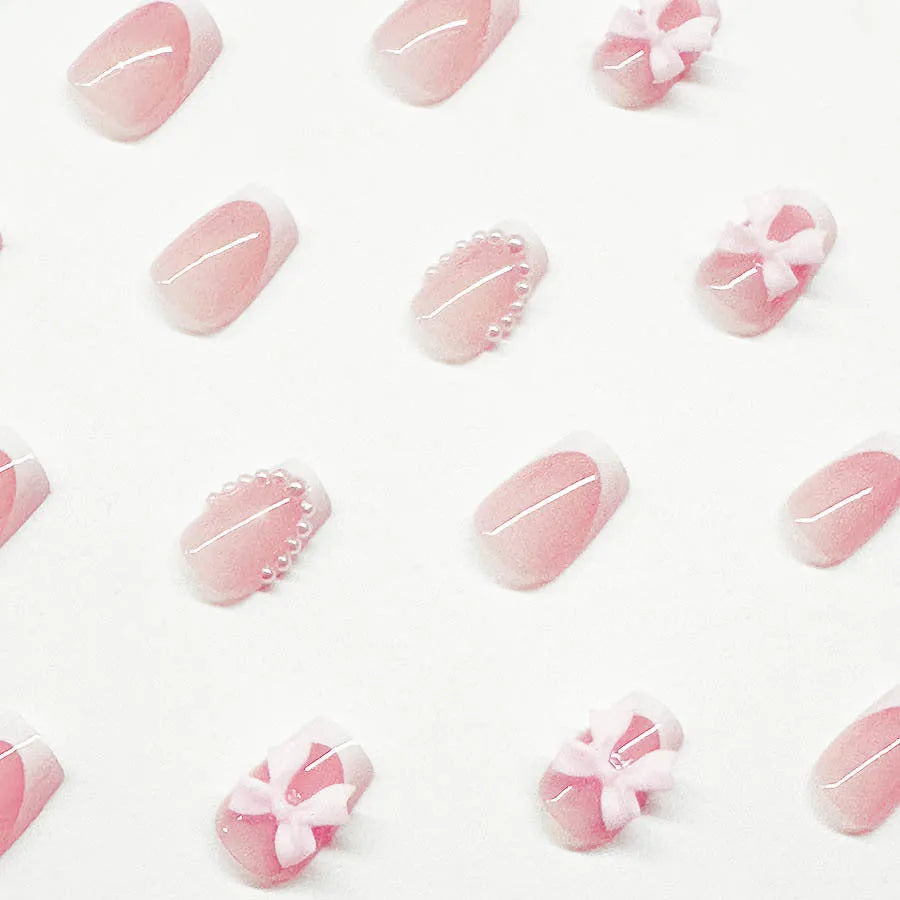 Short white French manicure press-on nails with bow designs and multiple patterns