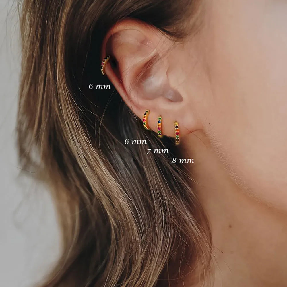 Geometric circle zircon stud earrings in gold, rose gold, or silver colour on a plain background.