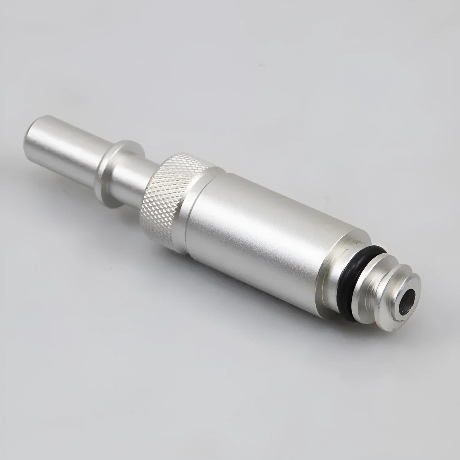 Silver metal transmission refuelling joint for automotive workshop use.