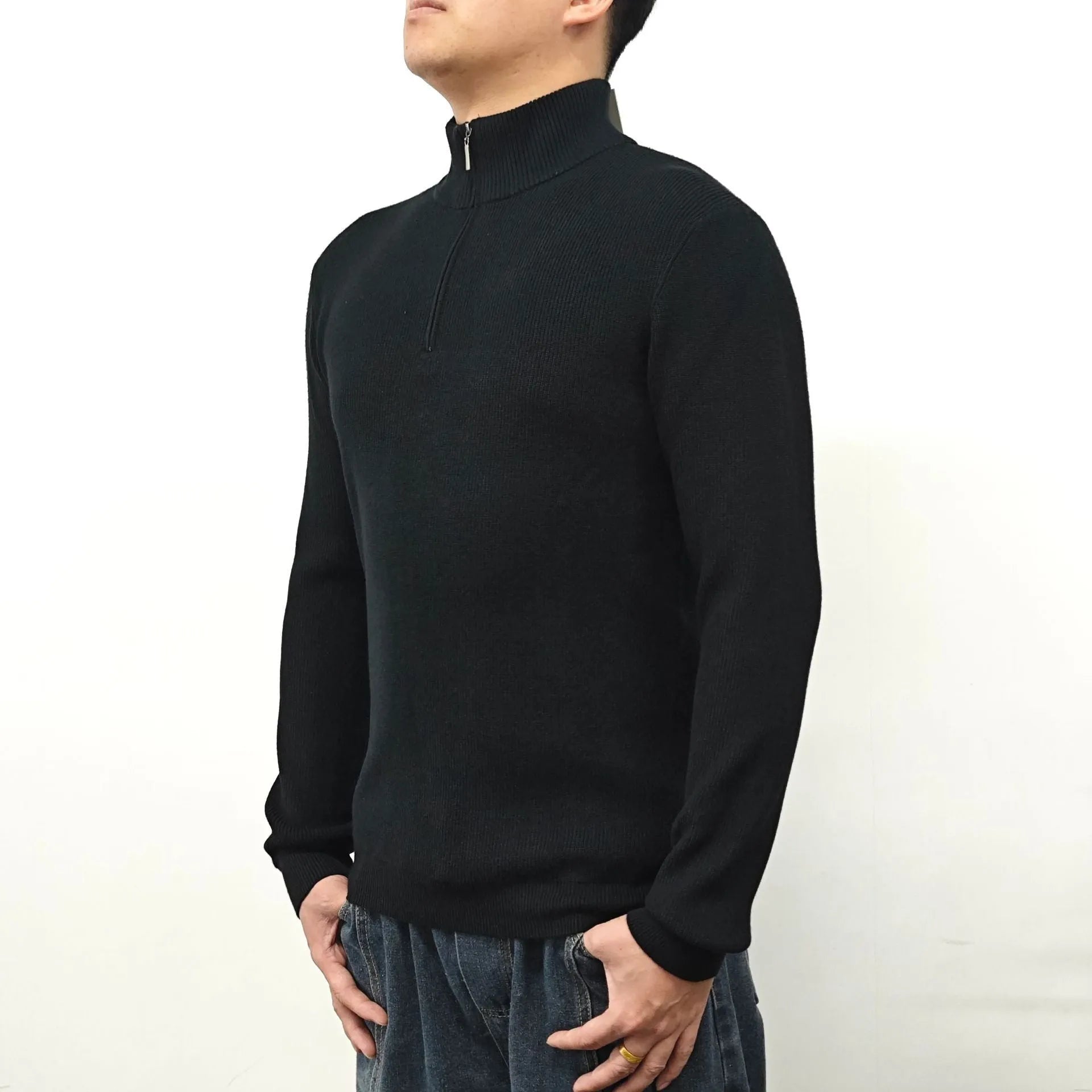 Man wearing a grey zip-up half-turtleneck sweater with long sleeves.