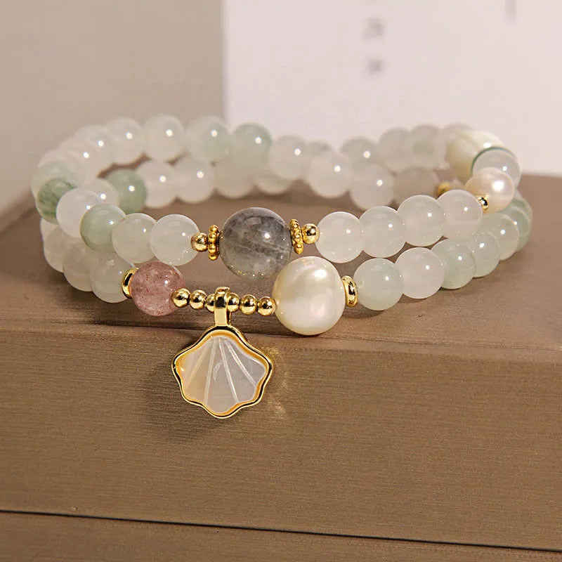 Women's emerald green crystal bracelet with gold ginkgo leaf pendant and rhinestone accents