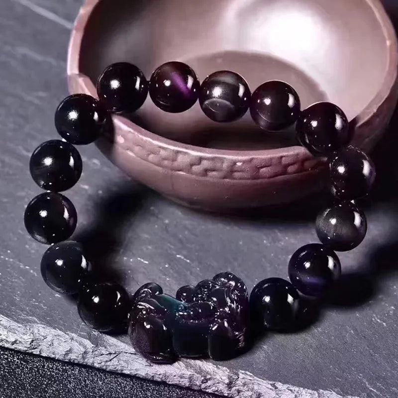 Natural ice colour obsidian crystal bracelet with spherical beads on a neutral background.