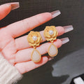 Gold Hong Kong style flower stud earrings with pearl rose design and ice flower pattern