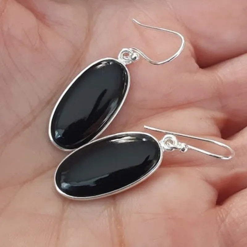 Women's earrings with black oval agate pendant and silver electroplated geometric Chinese style design.