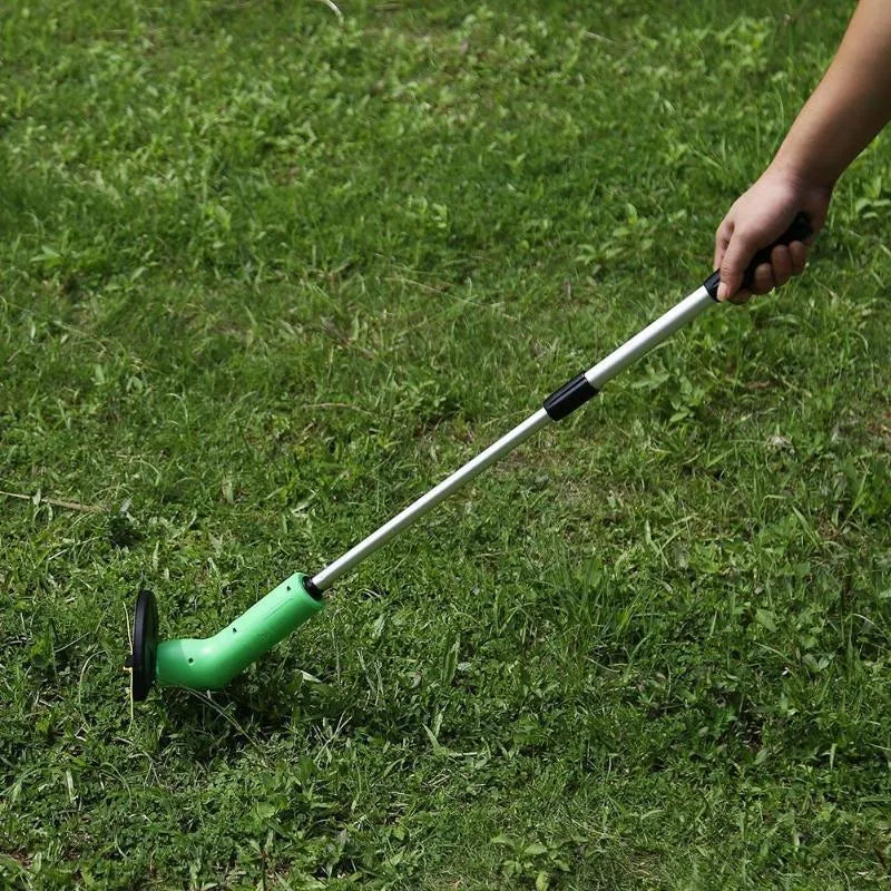 Cordless handheld lawn trimmer with extension pole and protective debris shield on a lawn.