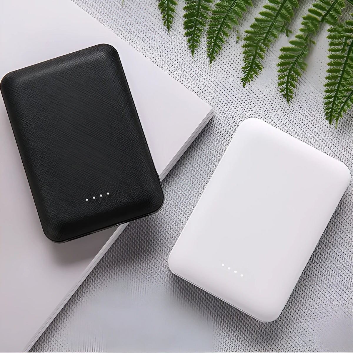 Black and white ultra-thin 10000mAh power bank showing multiple USB ports