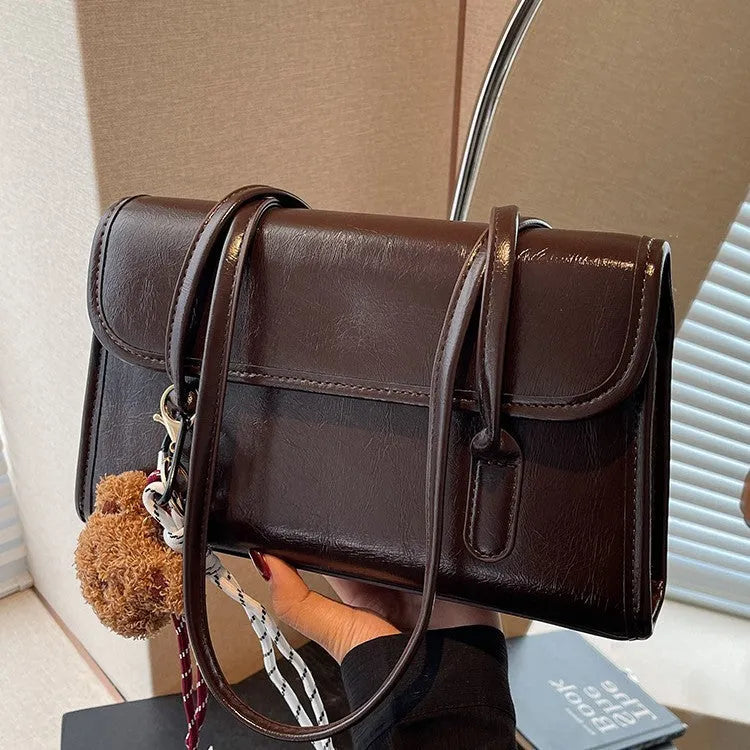 Women's brown PU Maillard shoulder bag with pendant detail, showing horizontal square shape and double straps.
